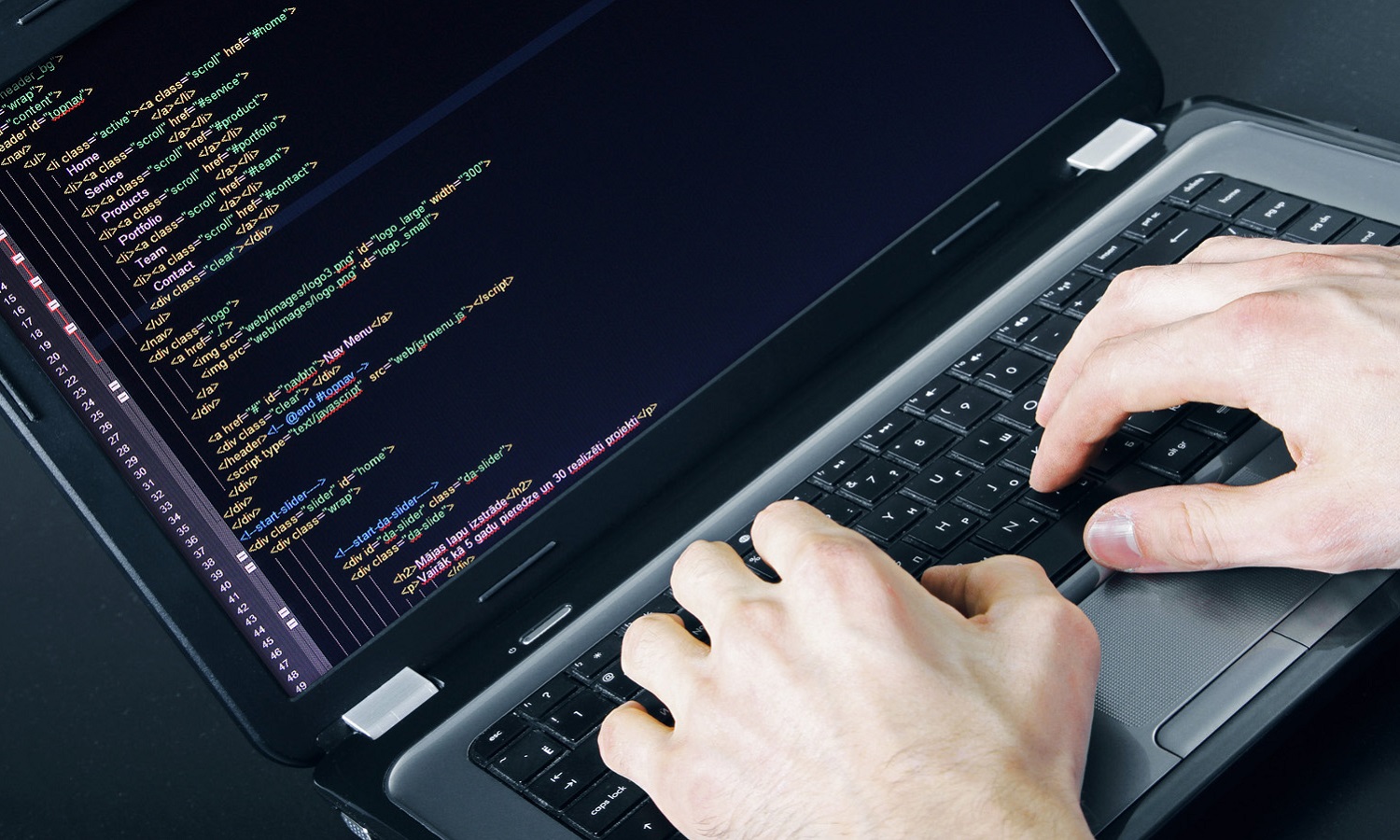 programmer occupation – writing programming code on laptop
